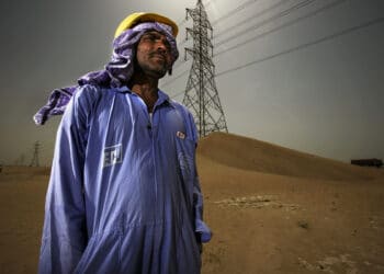 Sharjar, UAE, May 2006: A portrait of a migrant labourer in an area close to  Dubai where he is installing a well for ongoing construction. He is one of over a million construction workers working in Dubai. These sites are filled with construction labourers in Dubai live in labour camps.The camps are often over 2 hours away and the workers have just finished a 12 hour shift. The majority of labourers come to Dubai from India, Pakistan and Bangladesh. These workers operate in extreme temperatures in the desert climate, the majority earning under $200 a month. Many have to spend a third of that sum on food provided at the camps as part of their contract. Most sign recruitment contracts in their own countries which take them into debt for many years. Their passports are held by their employers once they reach the UAE and if the company owners abscond the workers are often abandoned without their documents or due payment. Over two thirds of the Dubai population is migrant labour with 1.1 million working in construction. Dubai is currently second only to Shanghai in terms of the scale of construction underway on a 24 hour basis. All this is woefully underscrutinised by the Ministry of Labour, there are currently only 80 government inspectors for over 200 000 construction companies. Recently there have been rumblings of discontent from the workers, with strikes at numerous sites over the non-payment of wages and harsh working conditions. In 2005, according to Human Rights Watch, there were 84 suicides by construction workers in Dubai. Photo by Brent Stirton/Getty Images.