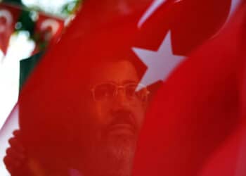 A portait of ousted Egyptian president Mohamed Morsi is seen through a Turkish flag during a rally on August 25, 2013 in Istanbul to support ousted Egyptian president Morsi and protest against killings in Syria and Egypt. The "Rabia sign" has become a symbol to remember the massacre in Egypt at the Rabaa al-Adawiya Square where the anti-coup protests took place.          AFP PHOTO / BULENT KILIC        (Photo credit should read BULENT KILIC/AFP via Getty Images)