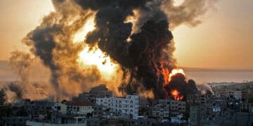 A fire rages at sunrise in Khan Yunis following an Israeli airstrike in the southern Gaza Strip, May 12, 2021. (Photo by Youssef Massoud/AFP via Getty Images)