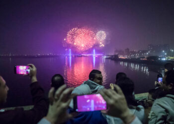People watch fireworks explode over the River Nile in the Egyptian capital Cairo during New Year's Eve celebrations on December 31, 2020. (Photo by Khaled DESOUKI / AFP) (Photo by KHALED DESOUKI/AFP via Getty Images)