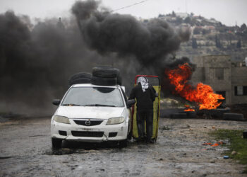 NABLUS, WEST BANK, PALESTINE - 2022/01/28: Palestinian protesters take cover from the Israeli soldiers, during the demonstration against Israeli settlements in the village of Kafr Qaddoum near the West Bank city of Nablus. (Photo by Nasser Ishtayeh/SOPA Images/LightRocket via Getty Images)
