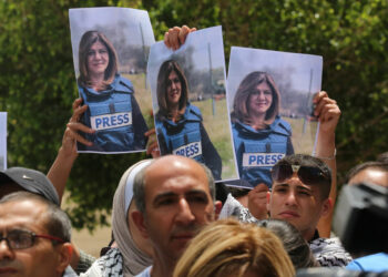NABLUS, WEST BANK - MAY 11: Press members holding photos of female reporter of Al-Jazeera television channel Shireen Abu Akleh, died as a result of fire opened by Israeli soldiers, are seen in front of the hospital as Akleh's dead body is brought to Al- Najah Hospital for autopsy in Nablus, West Bank on May 11, 2022. (Photo by Nedal Eshtayah/Anadolu Agency via Getty Images)