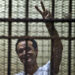 Egyptian political activist Ahmed Douma reacts as he stands behind dock bars during his trial in Cairo on June 3, 2013, on charges of insulting president Mohamed Morsi. Douma was convicted to serve six months in prison .  AFP PHOTO / KHALED DESOUKI        (Photo credit should read KHALED DESOUKI/AFP via Getty Images)
