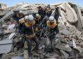 TOPSHOT - Members of the Syrian civil defence, known as the White Helmets, transport a casualty from the rubble of buildings in the village of Azmarin in Syria's rebel-held northwestern Idlib province at the border with Turkey following an earthquake, on February 7, 2023. (Photo by Omar HAJ KADOUR / AFP) (Photo by OMAR HAJ KADOUR/AFP via Getty Images)