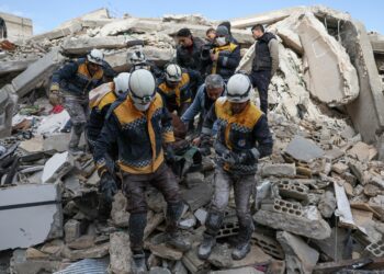 TOPSHOT - Members of the Syrian civil defence, known as the White Helmets, transport a casualty from the rubble of buildings in the village of Azmarin in Syria's rebel-held northwestern Idlib province at the border with Turkey following an earthquake, on February 7, 2023. (Photo by Omar HAJ KADOUR / AFP) (Photo by OMAR HAJ KADOUR/AFP via Getty Images)