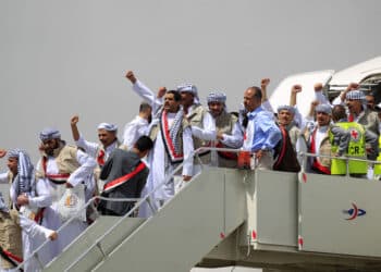 TOPSHOT - Yemeni Huthi rebel prisoners gesture as they disembark upon arrival at Sanaa airport on April 15, 2023. - Scores of prisoners of war, including Saudis, were freed on April 15 as part of a cross-border exchange between a Saudi-led military coalition and Yemen's Huthi rebels, the International Committee of the Red Cross said. (Photo by Mohammed HUWAIS / AFP) (Photo by MOHAMMED HUWAIS/AFP via Getty Images)