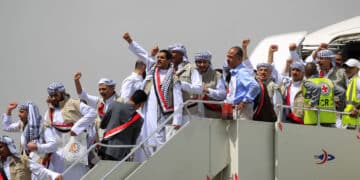 TOPSHOT - Yemeni Huthi rebel prisoners gesture as they disembark upon arrival at Sanaa airport on April 15, 2023. - Scores of prisoners of war, including Saudis, were freed on April 15 as part of a cross-border exchange between a Saudi-led military coalition and Yemen's Huthi rebels, the International Committee of the Red Cross said. (Photo by Mohammed HUWAIS / AFP) (Photo by MOHAMMED HUWAIS/AFP via Getty Images)