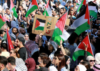 Jordanians shout slogans and wave flags during a protest outside the Israeli embassy in Amman following a strike which ripped through a Gaza hospital compound killing hundreds on October 17, 2023. Thousands rallied across the Arab world on October 18 to protest the deaths of hundreds of people in a strike on a Gaza hospital they blame on Israel, despite its denials. (Photo by Khalil MAZRAAWI / AFP) (Photo by KHALIL MAZRAAWI/AFP via Getty Images)