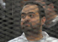 Egyptian prominent activicts Mohamed Adel stands in the accused dock during his trial on December 22, 2013, in Cairo. An Egyptian court sentenced three activists, Mohamed Adel, Ahmed Maher (unseen), the founder of the April 6 youth movement that led the revolt against former president Hosni Mubarak, and Ahmed Douma (unseen), all accused of spearheading the 2011 uprising against Mubarak to three years in jail for organising an unlicensed protest, judicial sources said. It was the first such verdict against non-Islamist protesters since the overthrow of president Mohamed Morsi in July, and was seen by rights groups as part of a widening crackdown on demonstrations by military-installed authorities. AFP PHOTO/STR