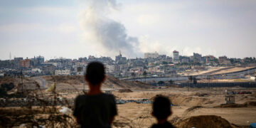 Boys watch smoke billowing during Israeli strikes east of Rafah in the southern Gaza Strip on May 13, 2024, amid the ongoing conflict between Israel and the Palestinian militant group Hamas. (Photo by AFP)