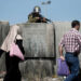 A female Israeli soldier stands guard at the Qalandia checkpoint, south of Ramallah, as thousands of Palestinians wait to cross from the West Bank to Jerusalem for Friday prayers at the Al-Aqsa Mosque compound, hours after a Palestinian teenager was killed by Israeli soldiers after throwing stones at an Israeli military patrol, on the third Friday of the Muslim holy fasting month of Ramadan on July 3, 2015. Israel has responded to recent violence by revoking permits for Palestinians living in the West Bank to visit relatives in the Gaza Strip and has limited Palestinian access to flashpoint Al-Aqsa mosque compound. AFP PHOTO / THOMAS COEX (Photo by THOMAS COEX / AFP)