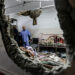 People inspect the damage in a room following Israeli bombardment at Nasser hospital in Khan Yunis in the southern Gaza Strip on December 17, 2023, amid ongoing battles between Israel and the Palestinian militant group Hamas. (Photo by STRINGER / AFP)