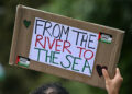 A Pro-Palestinian activist holds a placard reading 'From the River to the Sea' as they march through London, during a National Day of Action for Palestine on September 7, 2024. (Photo by JUSTIN TALLIS / AFP)