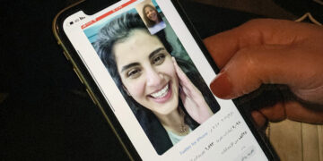 This picture taken February 10, 2021 in Saudi Arabia's capital Riyadh shows a woman viewing a tweet posted by the sister of Saudi activist Loujain al-Hathloul, Lina, showing a screenshot of them having a video call following Hathloul's release after nearly three years in detention. Saudi authorities on February 10 released the prominent women's rights activist, her family said, as the kingdom comes under renewed US pressure over its human rights record. Hathloul, 31, was arrested in May 2018 with about a dozen other women activists just weeks before the historic lifting of a decades-long ban on female drivers, a reform they had long campaigned for, sparking a torrent of international criticism. (Photo by Fayez Nureldine / AFP) (Photo by FAYEZ NURELDINE/AFP via Getty Images)