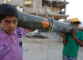 TOPSHOT - Palestinian children carry an empty US ammunition container in Khan Yunis in the southern Gaza Strip on May 16, 2024, amid the ongoing conflict between Israel and the militant group Hamas. (Photo by AFP) (Photo by -/AFP via Getty Images)