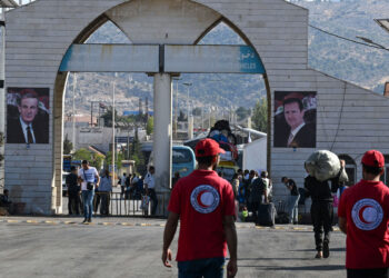 Syrian Red Crescent rescuers attend to displaced people arriving from Lebanon at the Jdeidat Yabus border crossing in southwestern Syria on October 7, 2024. The head of the UN refugee agency warned on October 6 that civilians in Lebanon were caught in the crossfire as Israel's intensified bombardment campaign forced many to flee while others were trapped under fire. (Photo by LOUAI BESHARA / AFP)