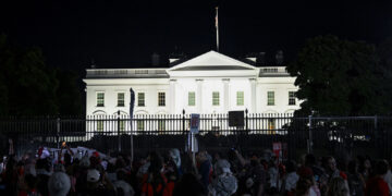 WASHINGTON D.C., UNITED STATES - JUNE 08: Demonstrators, wearing red clothes, hold banners and chant slogans in front of the White House as some of the pro-Palestinian demonstrators, gathered in front of the White House and called on the Joe Biden administration to 'red line', set up many tents in the area between the White House and the Washington Monument in the evening in Washington D.C, United States on June 08, 2024. (Photo by Fatih Aktas/Anadolu via Getty Images)