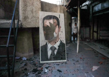 A defaced portrait of ousted Syrian president Bashar al-Assad stands in a ransacked government security facility, in Damascus, on December 8, 2024. Islamist-led rebels declared on December 8, that they have taken the Syrian capital in a lightning offensive, sending President Bashar al-Assad fleeing and ending five decades of Baath rule in Syria. (Photo by Rami al SAYED / AFP)