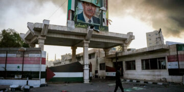 A defaced portrait of late Syrian president Hafez al-Assad stands above a ransacked government security facility, in Damascus, on December 8, 2024. Islamist-led rebels declared on December 8, that they have taken the Syrian capital in a lightning offensive, sending President Bashar al-Assad fleeing and ending five decades of Baath rule in Syria. (Photo by Rami al SAYED / AFP)