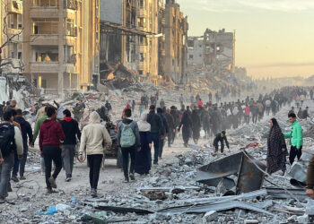 JABALIA, GAZA - JANUARY 19: Palestinians walk among debris of destroyed buildings as they return their houses after the announcement of ceasefire and hostage-prisoner swap deal between Hamas and Israel in Jabalia, Gaza on January 19, 2025. (Photo by Ramzi Mahmud/Anadolu via Getty Images)