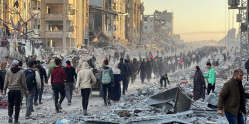 JABALIA, GAZA - JANUARY 19: Palestinians walk among debris of destroyed buildings as they return their houses after the announcement of ceasefire and hostage-prisoner swap deal between Hamas and Israel in Jabalia, Gaza on January 19, 2025. (Photo by Ramzi Mahmud/Anadolu via Getty Images)