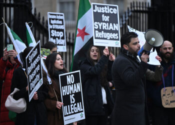 Supporters of the Syria Solidarity Campaign hold placards as they protest opposite 10 Downing Street in central London on December 28, 2024, calling on the UK government uphold its humanitarian obligations and end the suspension of asylum applications for Syrians. (Photo by JUSTIN TALLIS / AFP)