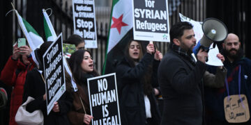 Supporters of the Syria Solidarity Campaign hold placards as they protest opposite 10 Downing Street in central London on December 28, 2024, calling on the UK government uphold its humanitarian obligations and end the suspension of asylum applications for Syrians. (Photo by JUSTIN TALLIS / AFP)