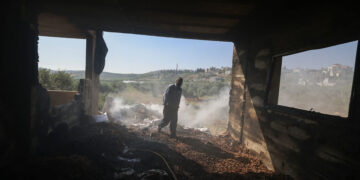 A Palestinian inspects the damage to a home in the village of Mughayir near Ramallah in the Israeli-occupied West Bank on April 13, 2024, after an attack by Israeli settlers on the village. (Photo by JAAFAR ASHTIYEH / AFP)